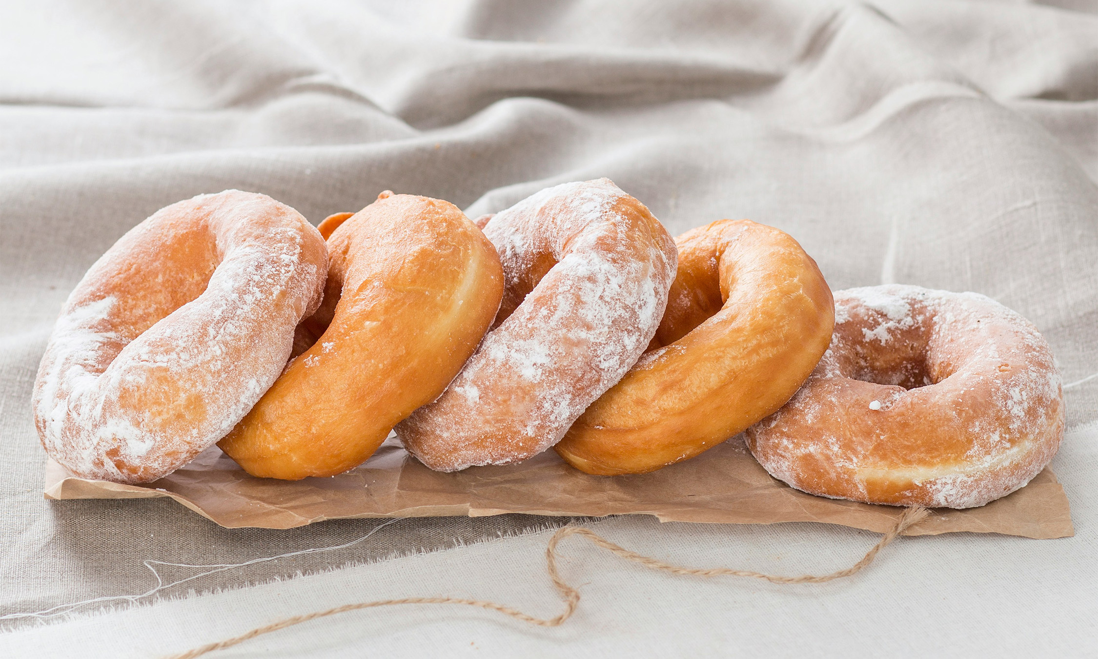 Five donuts layed on top of each other spread out in a row