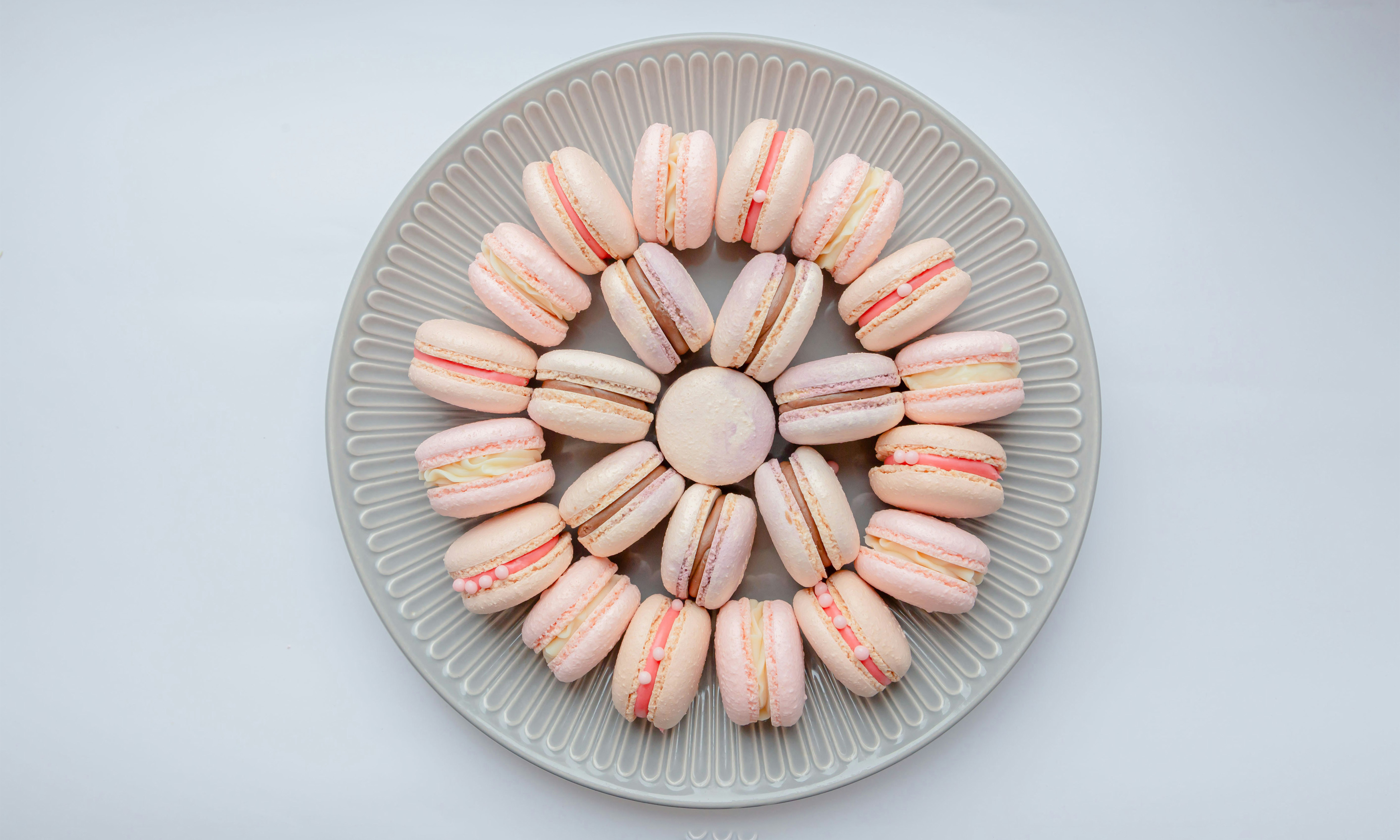 A circular plate of macarons filled with macarons arranged in a circular shape.